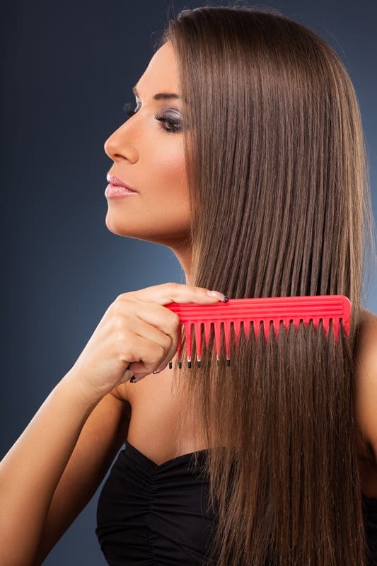 Beautiful young woman combs her hair
